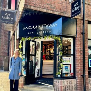 Entrance to the Lucy Pittaway Art Gallery in York, with open doors, artwork in the window and a visitor standing outside.